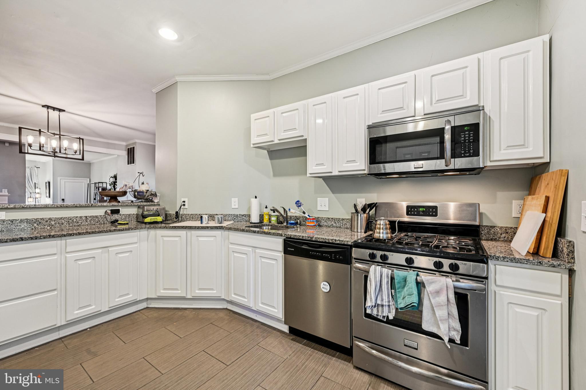616 East 33rd Street Baltimore, MD 21218 - Photo 16 of 44 a kitchen with stainless steel appliances granite countertop grey cabinets a stove a sink and dishwasher