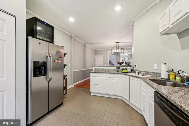 a kitchen with granite countertop a refrigerator and a sink