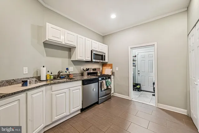 a kitchen with granite countertop a sink and stainless steel appliances