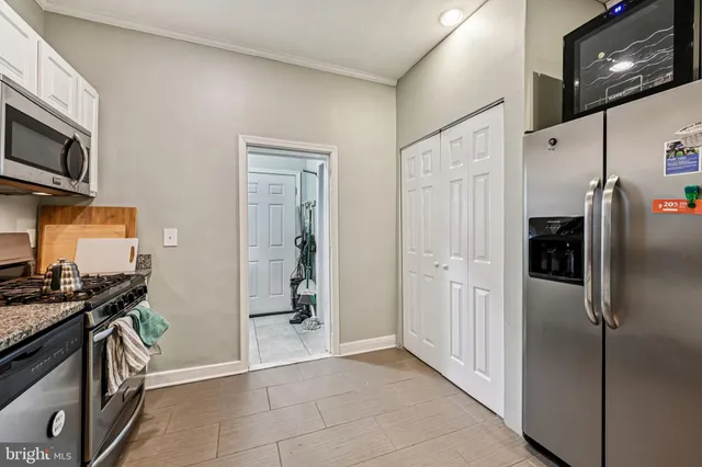 a kitchen with stainless steel appliances granite countertop a refrigerator and a stove top oven
