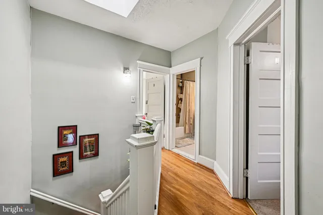a view of a hallway with bathroom and wooden floor