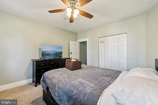 a bedroom with a bed and a flat tv screen on dresser