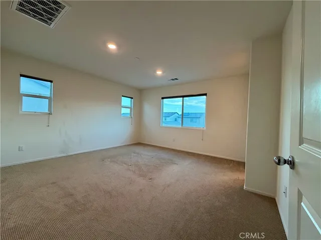 an empty room with windows and closet