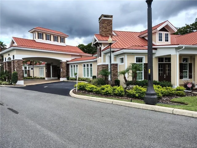 a view of a house with floor to ceiling windows and a table and chairs