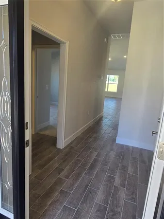 an empty room with wooden floor and entrance