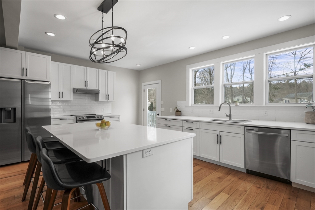 40 Haskell Street Beverly, MA 01915 - Photo 8 of 38 a kitchen with stainless steel appliances granite countertop a sink a stove a refrigerator and island with wooden floor