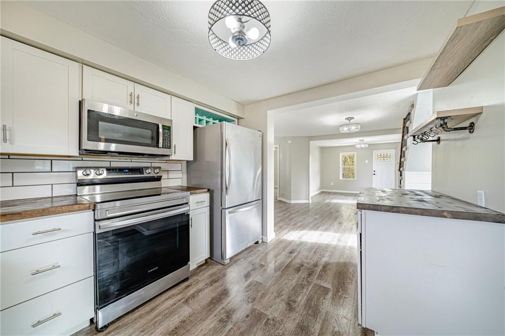 1109 Baggaley Avenue Latrobe, PA 15650 - Photo 11 of 36 a kitchen with granite countertop a stove top oven a sink and dishwasher a oven with wooden floor