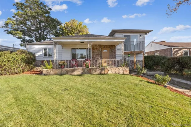 a view of a house with backyard and sitting area