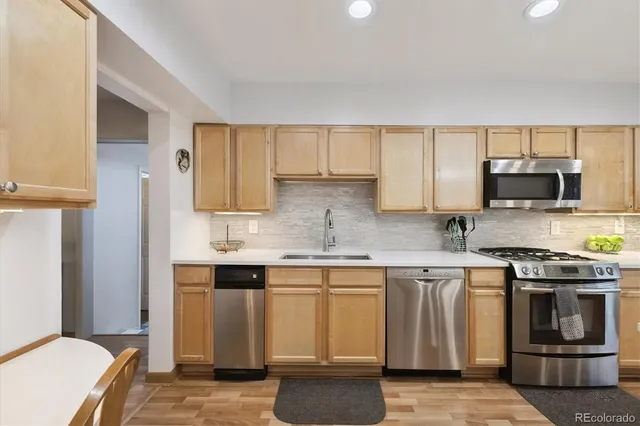 a kitchen with stainless steel appliances granite countertop a stove a sink and a microwave