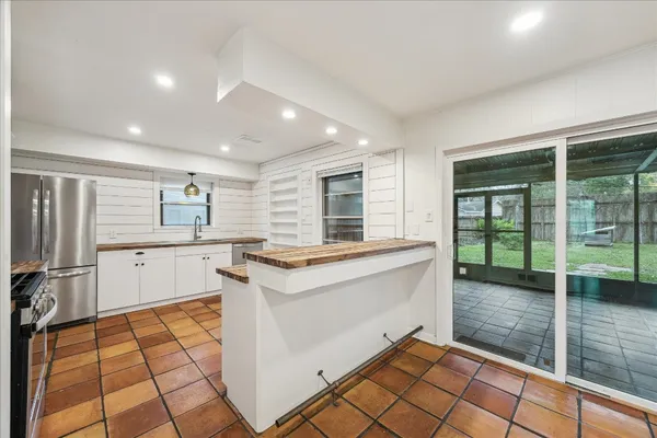 a kitchen with granite countertop a stove a sink and a refrigerator