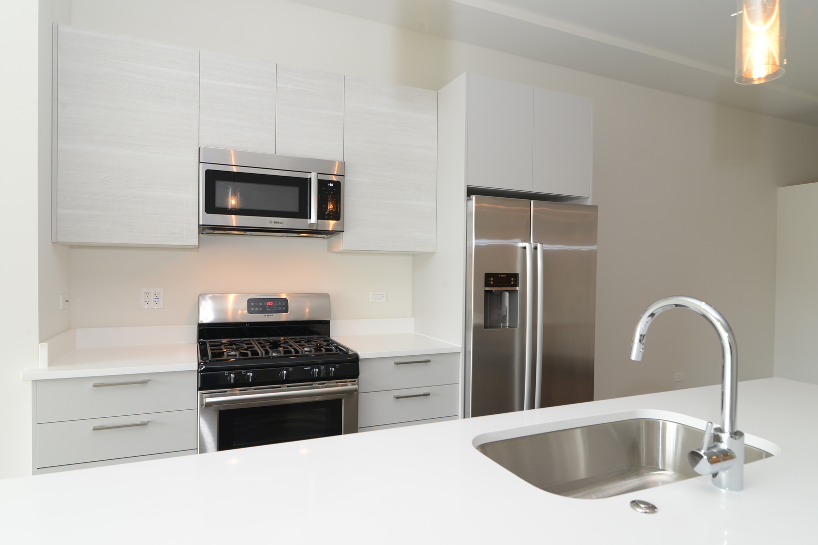858 North Franklin Street, Unit 503 Chicago, IL 60610 - Photo 5 of 9 a kitchen with stainless steel appliances kitchen island a white stove top oven and wooden cabinets