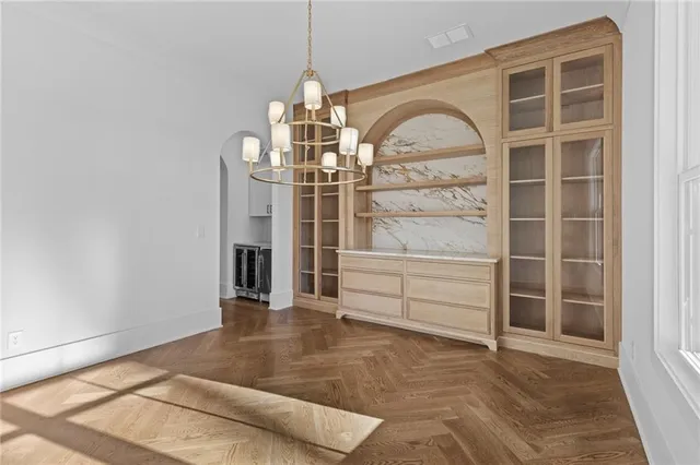 a view of a kitchen with kitchen island a large counter top space a sink stainless steel appliances and cabinets