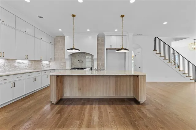 a view of a hallway with wooden floor and stairs