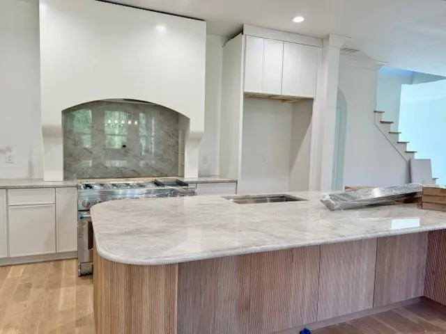 an empty room with wooden floor fireplace and windows