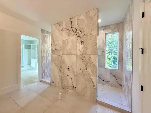 a view of a kitchen with kitchen island a large counter top space a sink stainless steel appliances and cabinets