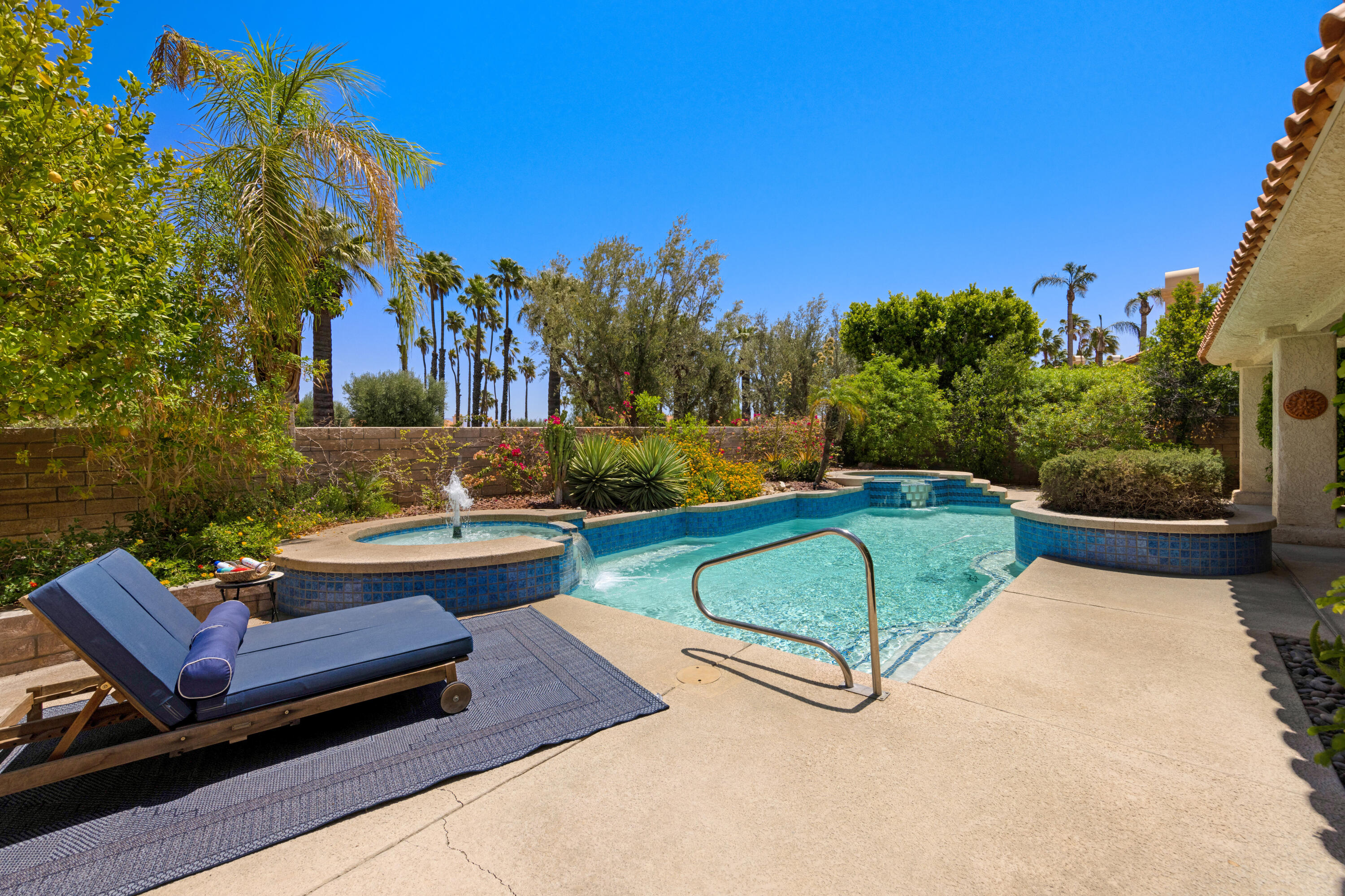 a view of a backyard with couches and swimming pool