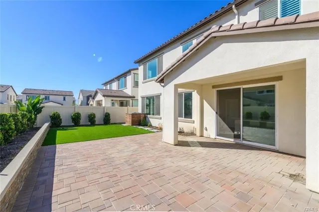 a view of a white house with a small yard and potted plants
