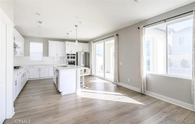 a kitchen with kitchen island white cabinets and wooden floor