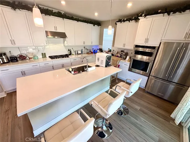 a kitchen with stainless steel appliances a stove a sink a refrigerator and cabinets