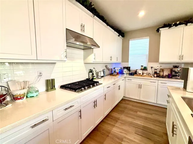 a kitchen with granite countertop a sink a window stainless steel appliances and cabinets