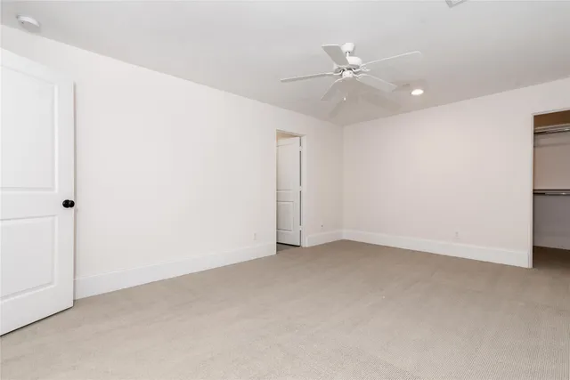 an empty room with a ceiling fan and a window
