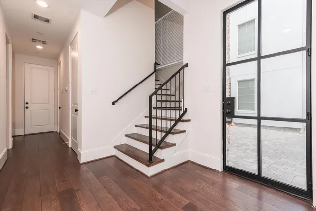 a view of a hallway with wooden floor and entryway