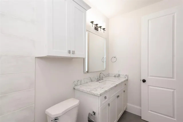 a bathroom with a sink a toilet and mirror