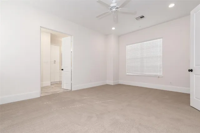 an empty room with fan and windows