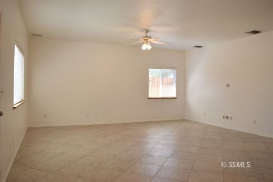 919 Sims Street Ridgecrest, CA 93555 - Photo 4 of 32 an empty room with chandelier fan and windows
