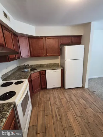 a kitchen with a cabinets a sink and wooden floor