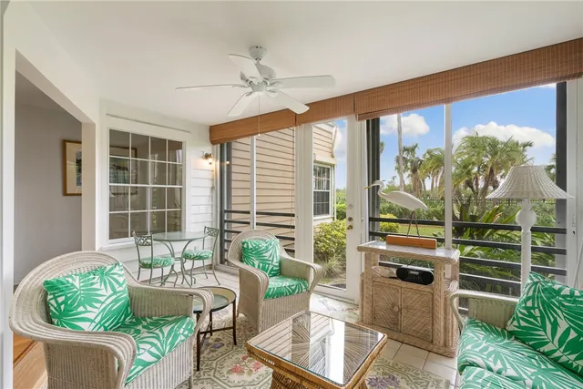 a living room with patio furniture and a potted plant