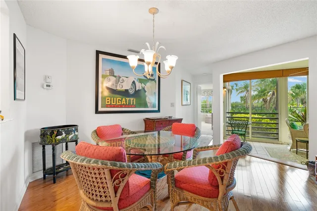 a view of a dining room with furniture a chandelier and wooden floor