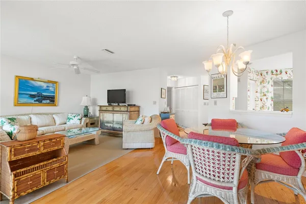 a living room with furniture a flat screen tv and kitchen view