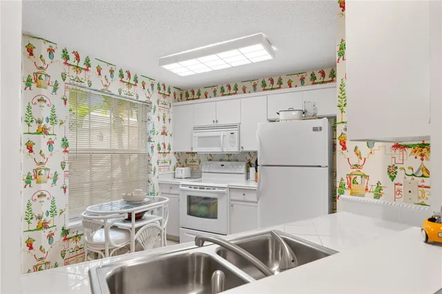 a kitchen with a sink a stove and cabinets