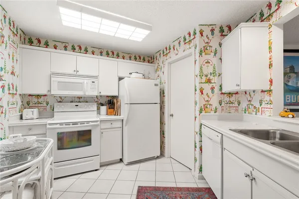 a kitchen with white cabinets and white appliances