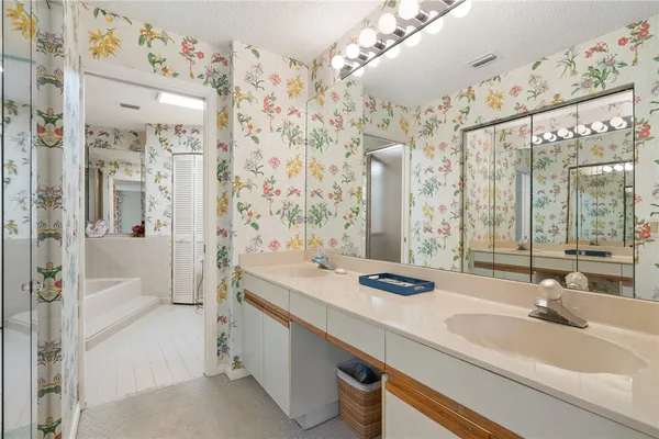 a bathroom with double vanity sinks and a shower