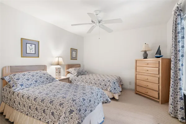 a bedroom with a bed and a lamp on dresser