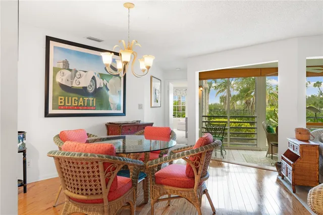 a dining room with furniture a large window and a chandelier
