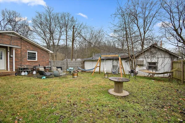 a view of a yard with wooden fence
