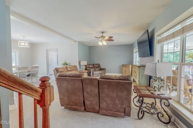 a living room with furniture a flat screen tv and a large window