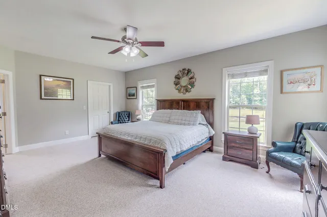 a bedroom with a bed and a dresser next to a window