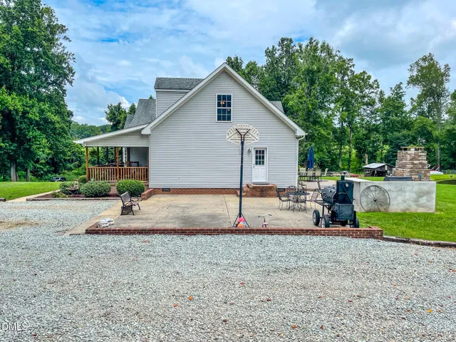 a view of a house with backyard and trees