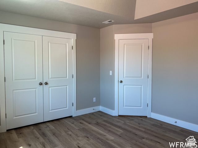 702 North 100 West Logan, UT 84321 - Photo 54 of 58 Unfurnished bedroom featuring wood finished floors, a closet, baseboards, and visible vents