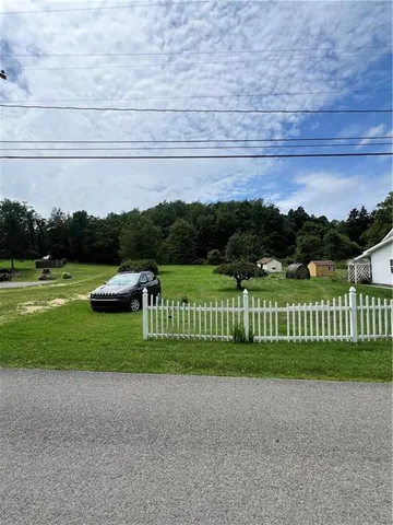 a view of green field with wooden fence