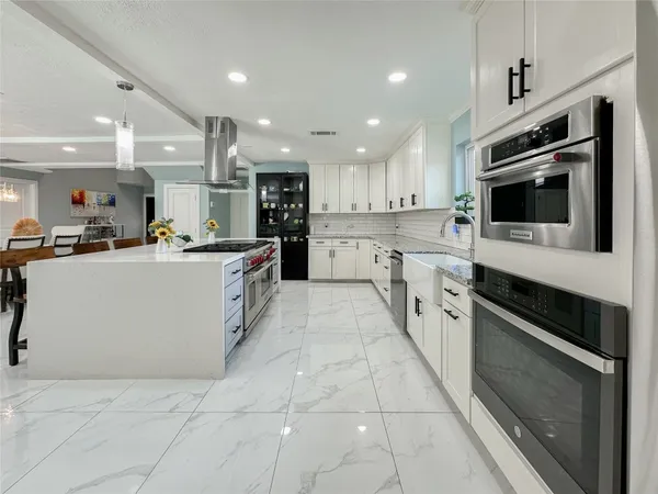 a kitchen with stainless steel appliances granite countertop a sink and a stove