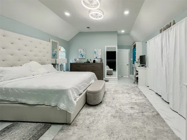 a spacious bedroom with a bed and a dresser