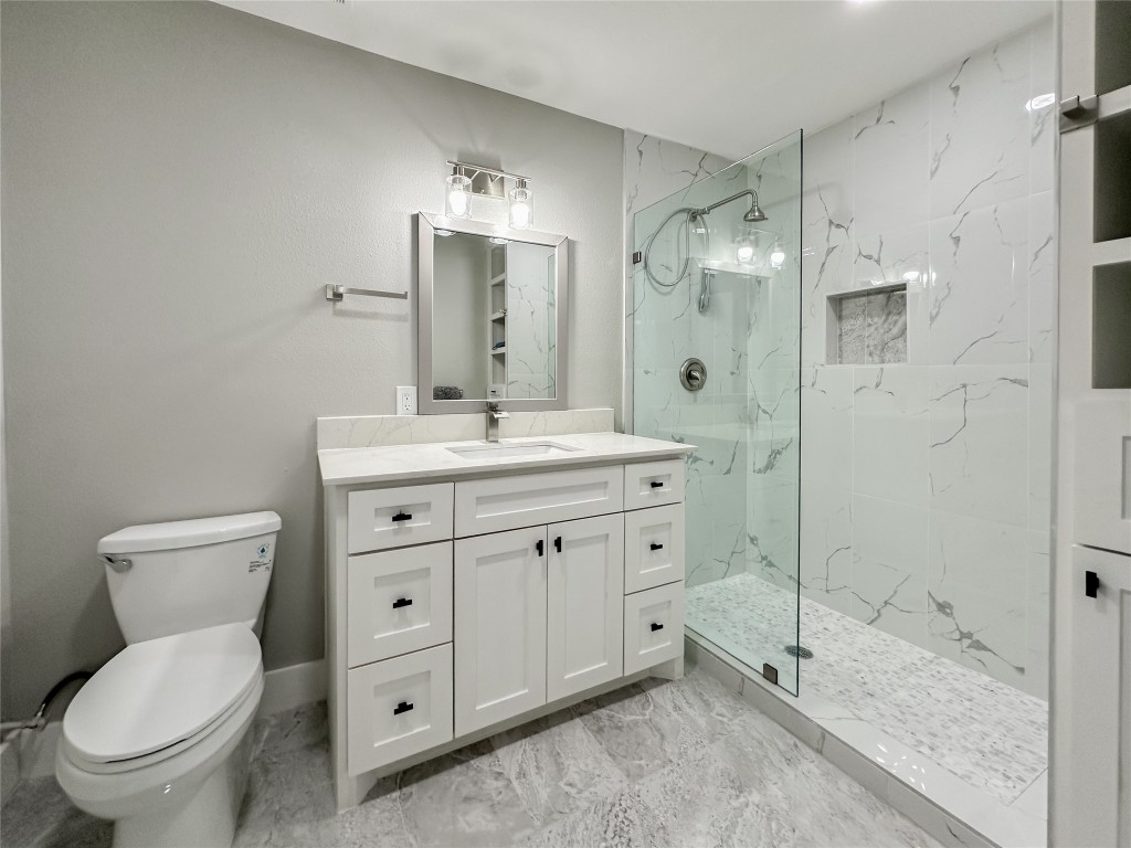 19310 Enchanted Oaks Drive Spring, TX 77388 - Photo 31 of 49 a bathroom with a granite countertop sink toilet and shower