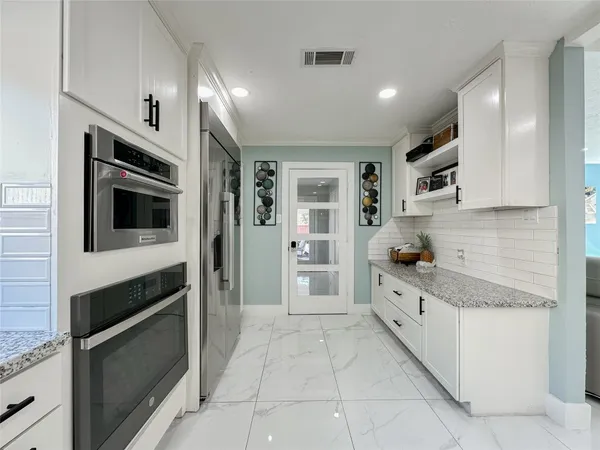 a kitchen with stainless steel appliances a stove a sink a counter top space and cabinets
