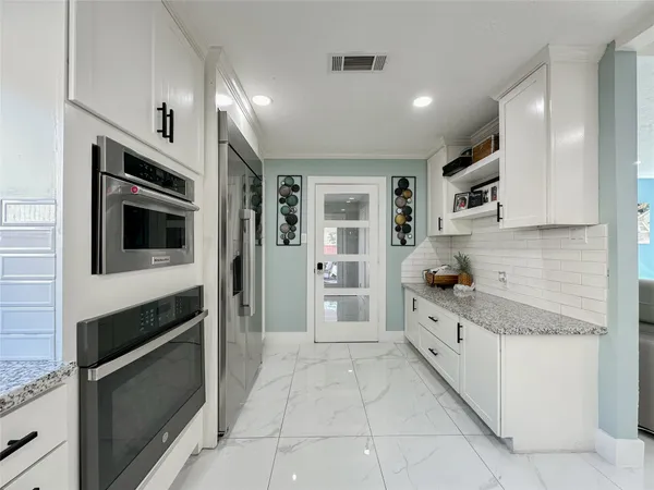 a kitchen with stainless steel appliances a stove a sink a counter top space and cabinets