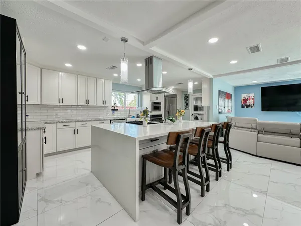 a kitchen with stainless steel appliances kitchen island granite countertop a table and chairs in it